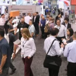 People talking and walking around a conference exhibit hall.