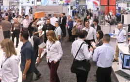 People talking and walking around a conference exhibit hall.